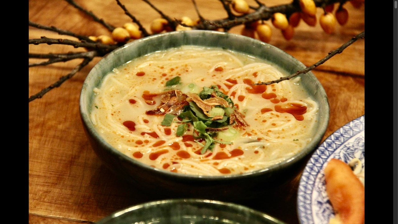 Soupe vietnamienne au lait de coco, sriracha, fines herbes et oignons frits